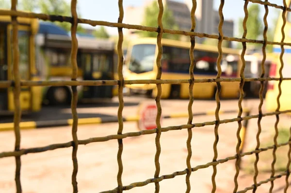 Bus depot through a metal fence