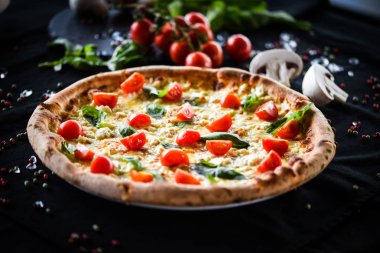 Kiraz domatesli lezzetli İtalyan pizzası, taze fesleğen ve gorgonzola peyniri.