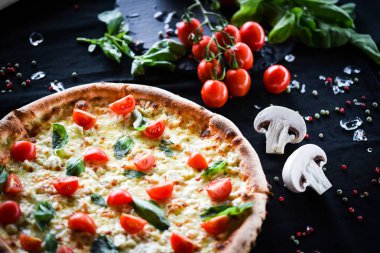 Kiraz domatesli lezzetli İtalyan pizzası, taze fesleğen ve gorgonzola peyniri.