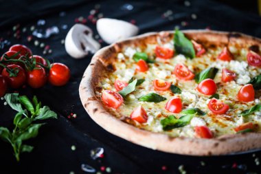 Kiraz domatesli lezzetli İtalyan pizzası, taze fesleğen ve gorgonzola peyniri.