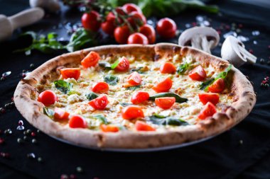Kiraz domatesli lezzetli İtalyan pizzası, taze fesleğen ve gorgonzola peyniri.