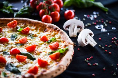 Kiraz domatesli lezzetli İtalyan pizzası, taze fesleğen ve gorgonzola peyniri.