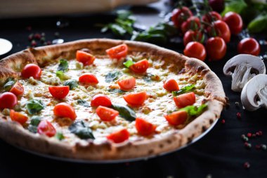 Kiraz domatesli lezzetli İtalyan pizzası, taze fesleğen ve gorgonzola peyniri.