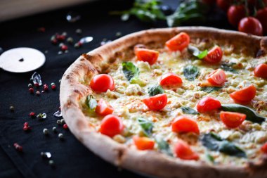 Kiraz domatesli lezzetli İtalyan pizzası, taze fesleğen ve gorgonzola peyniri.