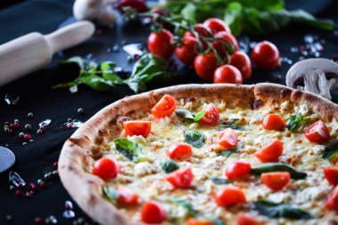 Kiraz domatesli lezzetli İtalyan pizzası, taze fesleğen ve gorgonzola peyniri.