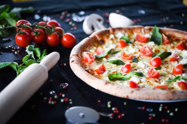 Kiraz domatesli lezzetli İtalyan pizzası, taze fesleğen ve gorgonzola peyniri.