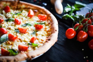 Kiraz domatesli lezzetli İtalyan pizzası, taze fesleğen ve gorgonzola peyniri.