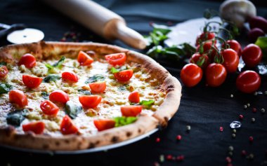 Kiraz domatesli lezzetli İtalyan pizzası, taze fesleğen ve gorgonzola peyniri.