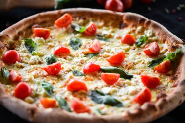 Kiraz domatesli lezzetli İtalyan pizzası, taze fesleğen ve gorgonzola peyniri.