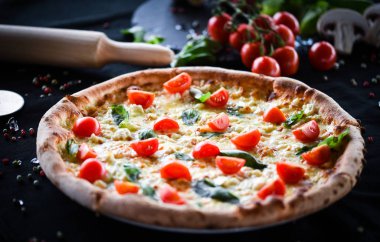 Kiraz domatesli lezzetli İtalyan pizzası, taze fesleğen ve gorgonzola peyniri.