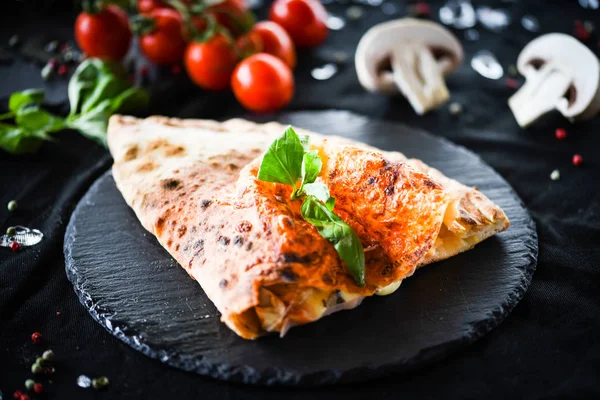 Lezzetli İtalyan calzone pizza yemeği ve taze malzemeler.