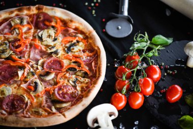 Taze malzemeli lezzetli İtalyan pizza kaprisiosa - sebze, peynir, jambon, domates sosu ve fesleğen