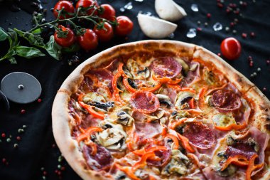 Taze malzemeli lezzetli İtalyan pizza kaprisiosa - sebze, peynir, jambon, domates sosu ve fesleğen