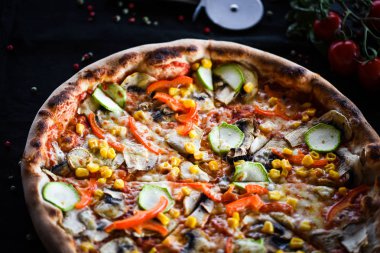 Taze sebze, peynir ve domates soslu lezzetli İtalyan vejetaryen pizzası.