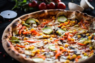 Taze sebze, peynir ve domates soslu lezzetli İtalyan vejetaryen pizzası.