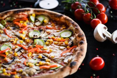 Taze sebze, peynir ve domates soslu lezzetli İtalyan vejetaryen pizzası.