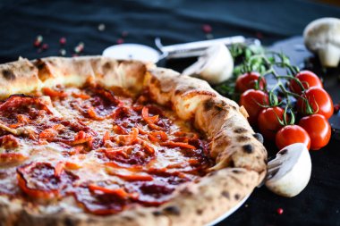 Çift parmesanlı hamur içinde sucuklu ve salamlı İtalyan pizzası. 