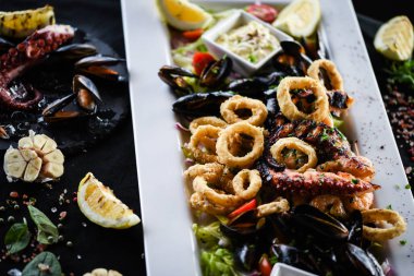 Ahtapot, karides, karides, karides, kabuk, mürekkep balığı ve limon soslu taze balık karışımı lezzetli bir deniz ürünleri tabağı.