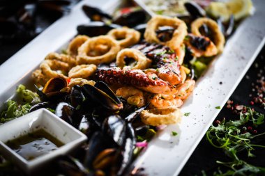 Ahtapot, karides, karides, karides, kabuk, mürekkep balığı ve limon soslu taze balık karışımı lezzetli bir deniz ürünleri tabağı.