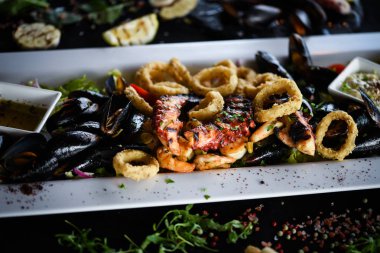 Ahtapot, karides, karides, karides, kabuk, mürekkep balığı ve limon soslu taze balık karışımı lezzetli bir deniz ürünleri tabağı.