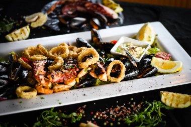 Ahtapot, karides, karides, karides, kabuk, mürekkep balığı ve limon soslu taze balık karışımı lezzetli bir deniz ürünleri tabağı.