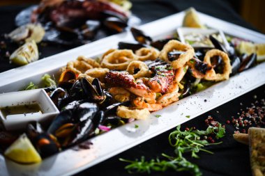 Ahtapot, karides, karides, karides, kabuk, mürekkep balığı ve limon soslu taze balık karışımı lezzetli bir deniz ürünleri tabağı.