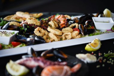 Ahtapot, karides, karides, karides, kabuk, mürekkep balığı ve limon soslu taze balık karışımı lezzetli bir deniz ürünleri tabağı.