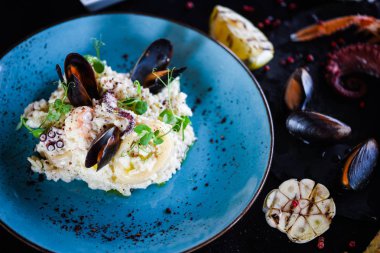 Taze sebzelerle lezzetli deniz ürünleri pilavı - ahtapot, karides, kabuk, mürekkep balığı ve özel sebze sosuyla karıştırılmış karides.