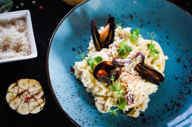 Taze sebzelerle lezzetli deniz ürünleri pilavı - ahtapot, karides, kabuk, mürekkep balığı ve özel sebze sosuyla karıştırılmış karides.