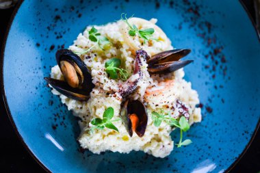 Taze sebzelerle lezzetli deniz ürünleri pilavı - ahtapot, karides, kabuk, mürekkep balığı ve özel sebze sosuyla karıştırılmış karides.