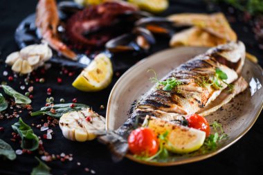 Izgara limon soslu ızgara balık, otlar, tuz ve biber.