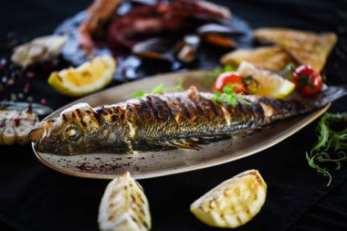 Izgara limon soslu ızgara balık, otlar, tuz ve biber.