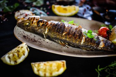 Izgara limon soslu ızgara balık, otlar, tuz ve biber.