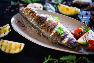 Izgara limon soslu ızgara balık, otlar, tuz ve biber.