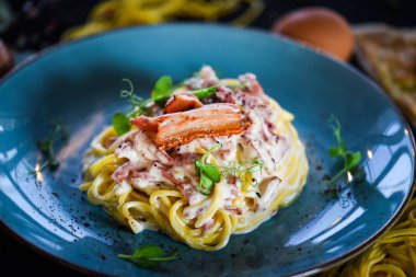 Lezzetli malzemeli lezzetli İtalyan spagetti carbonara - yumurta, jambon, krema ve baharatlar
