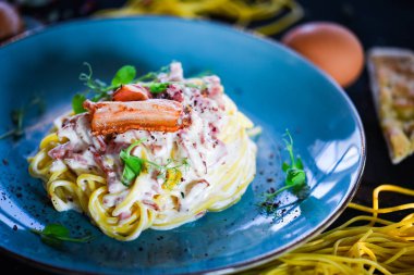 Lezzetli malzemeli lezzetli İtalyan spagetti carbonara - yumurta, jambon, krema ve baharatlar