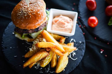 Lezzetli patates kızartmalı ev yapımı hamburger ve baharatlı mayonez sosu.