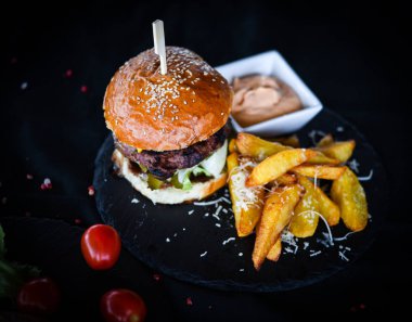 Lezzetli patates kızartmalı ev yapımı hamburger ve baharatlı mayonez sosu.