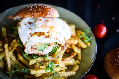 Lezzetli ev yapımı tavuk burgeri patates kızartması ve kızarmış yumurta.