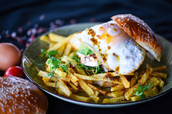 вкусные домашние куриные бургеры с картошкой фри и яичницей
