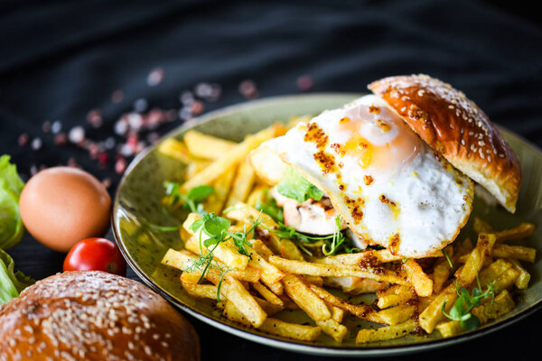 вкусные домашние куриные бургеры с картошкой фри и яичницей
