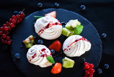 Taze meyve ve şeker şuruplu lezzetli pavlova tatlısı