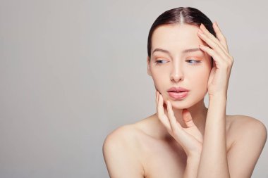 Beauty Woman portresi. Mükemmel Taze Temiz Ciltli Güzel Spa Mankeni Kız. Esmer kadın kendi elleriyle yüzüne dokunuyor. Gençlik ve Cilt Bakımı