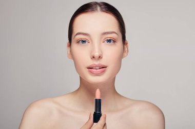 Güzel ve narin bir kız. Dudakları dolgun, omuzları çıplak. Sağ elinde ruj izi var.