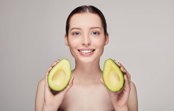 photo portrait of attractive and happy brown-haired nude lady with perfect pure shine skin beautiful smile and avocado in hands