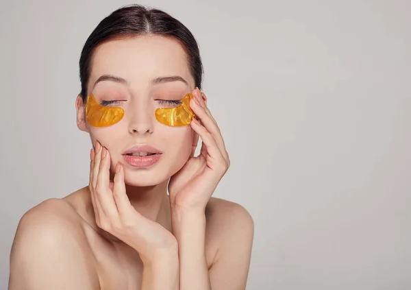 Máscara para remover rugas e olheiras. Uma mulher cuida da pele delicada ao redor dos olhos. Procedimentos cosméticos . — Fotografia de Stock
