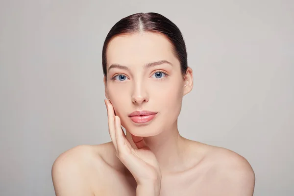 Mulher bonita com pele limpa e fresca e escura ouvir tocar seu próprio rosto com a mão direita olhando em linha reta. Cosmetologia, beleza e spa . — Fotografia de Stock