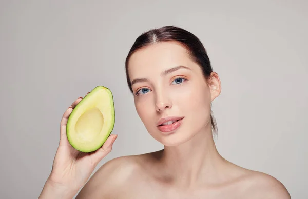 Nude lady looking streight with perfect shine skin with avocado in the right hand — Stock Photo, Image