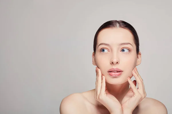 Una chica sofisticada elegante con labios llenos, cabello y piel delicada limpia radiante en el fondo. Señora mirando a un lado. Spa, cosmetología. Una mujer bien arreglada. Cuidado facial de la piel . —  Fotos de Stock