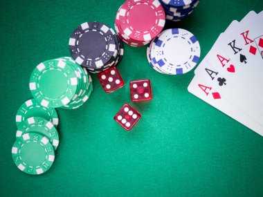 Aslar ve papazlardan oluşan poker dolu yeşil masa üzerinde kırmızı küpler ve poker fişleriyle